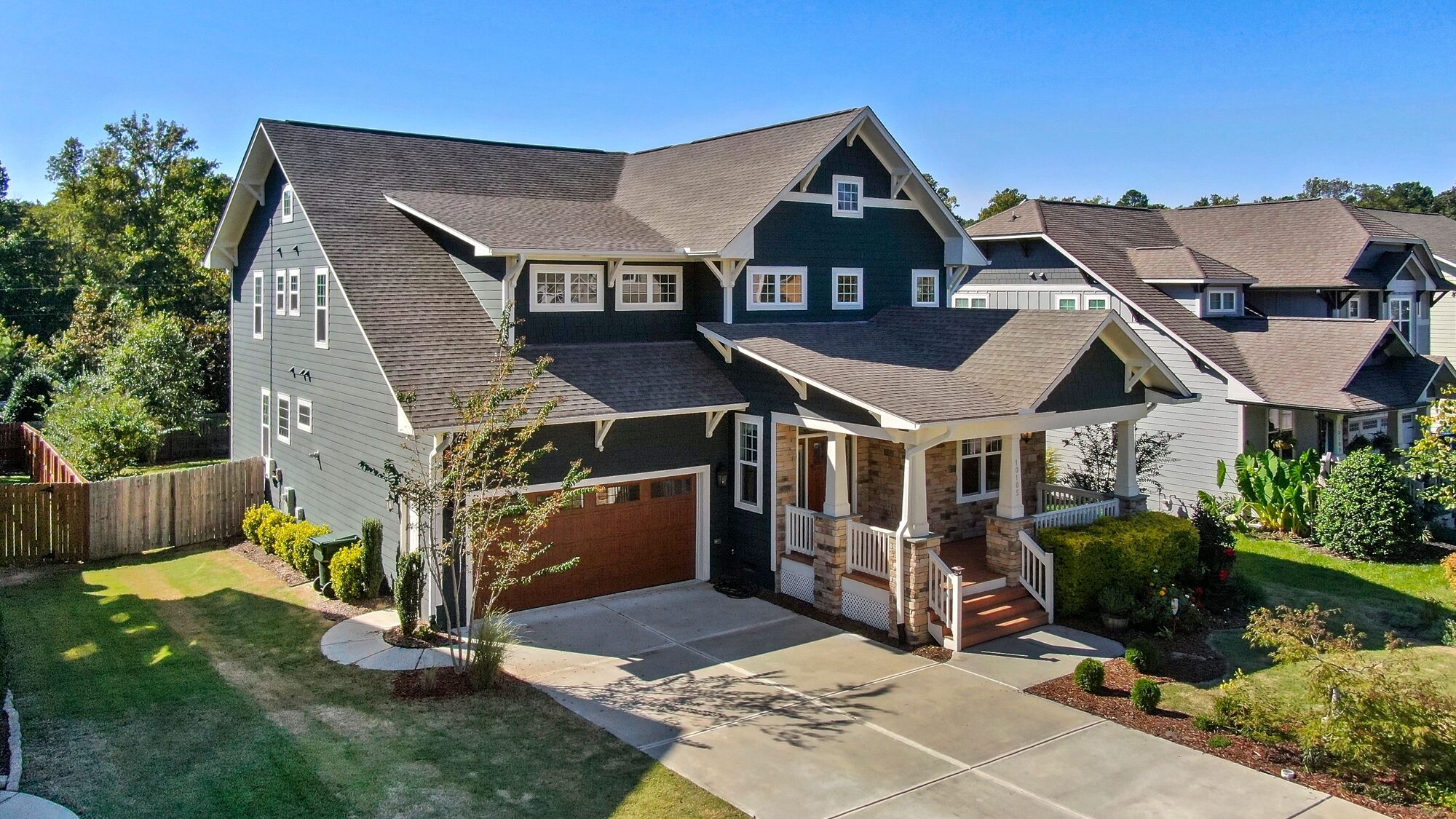 A Craftsman-style custom home with a spacious front porch and manicured lawn
